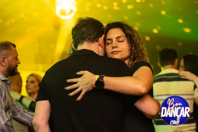 Casal abraçado sob luz amarela