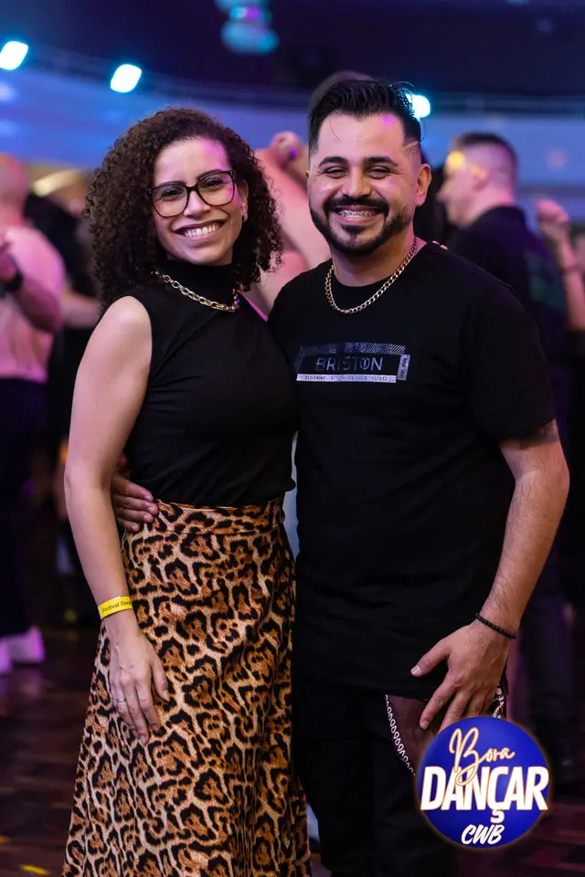 Casal sorrindo abraçado no salão